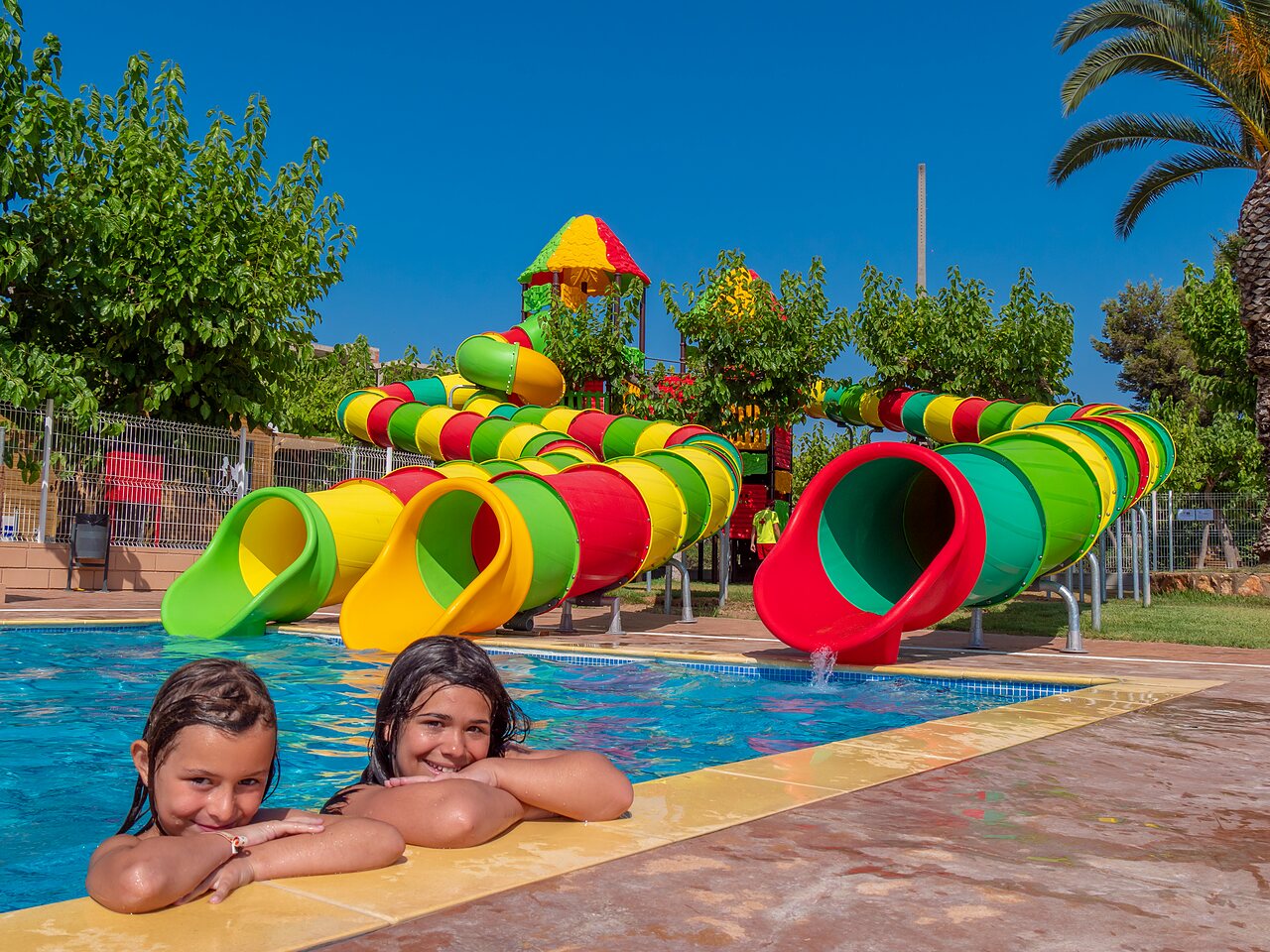 Waterglijbanen en kinderen in het zwembad op camping CAPFUN Alba in CREIXELL (43).