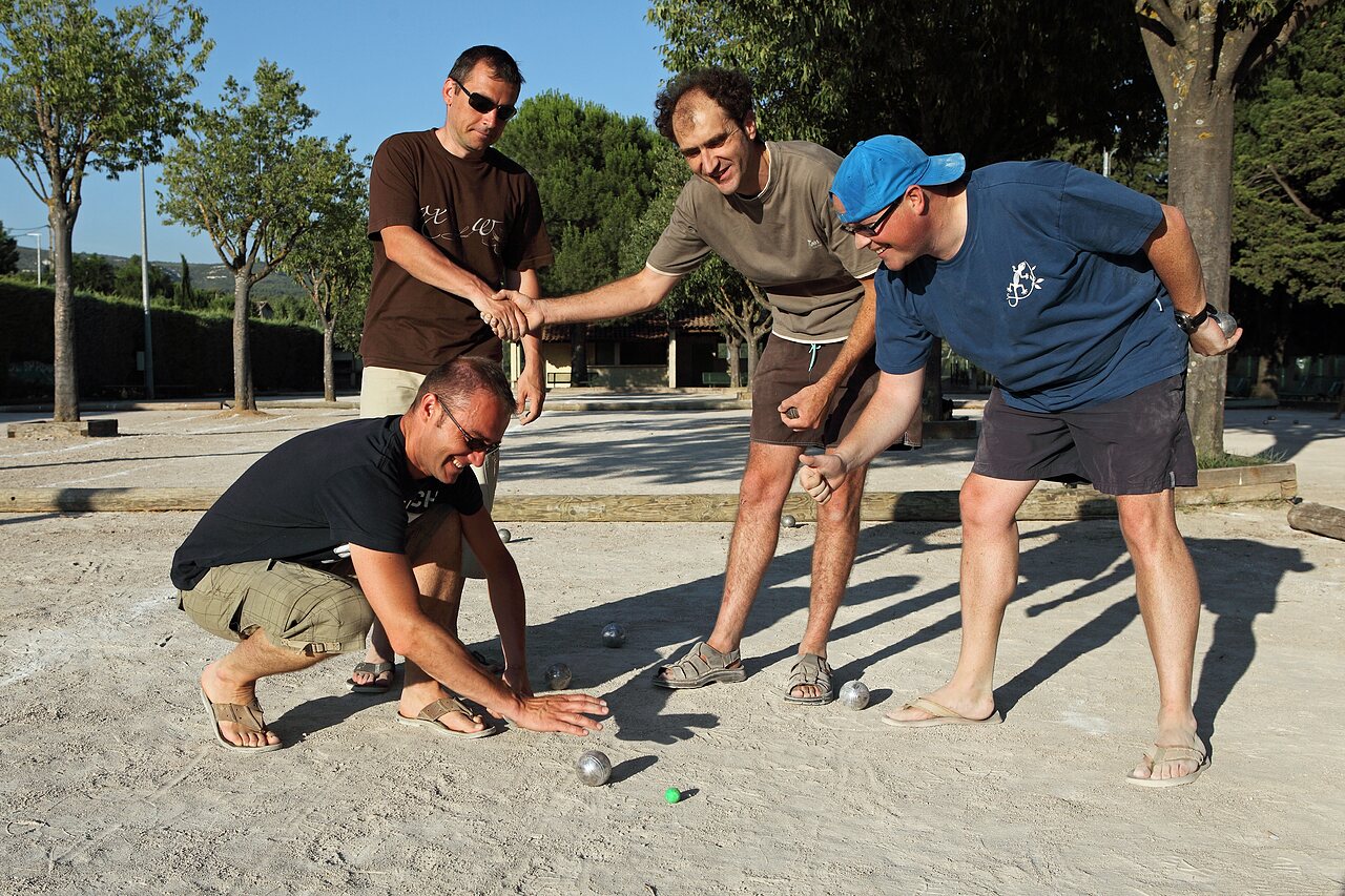 Mannen spelen jeu de boules op een gravelbaan op camping CAPFUN Alba in CREIXELL (43).