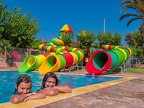 Buitenzwembad met kleurrijke waterglijbanen en kinderen op camping CAPFUN Alba in CREIXELL (43).