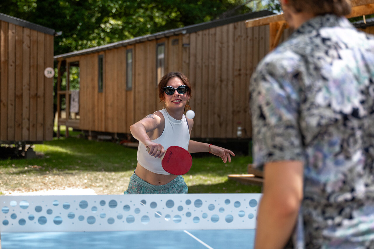 Lachende vrouw speelt tafeltennis bij accommodaties op camping CLICOCHIC Aloua in Sevrier (74).