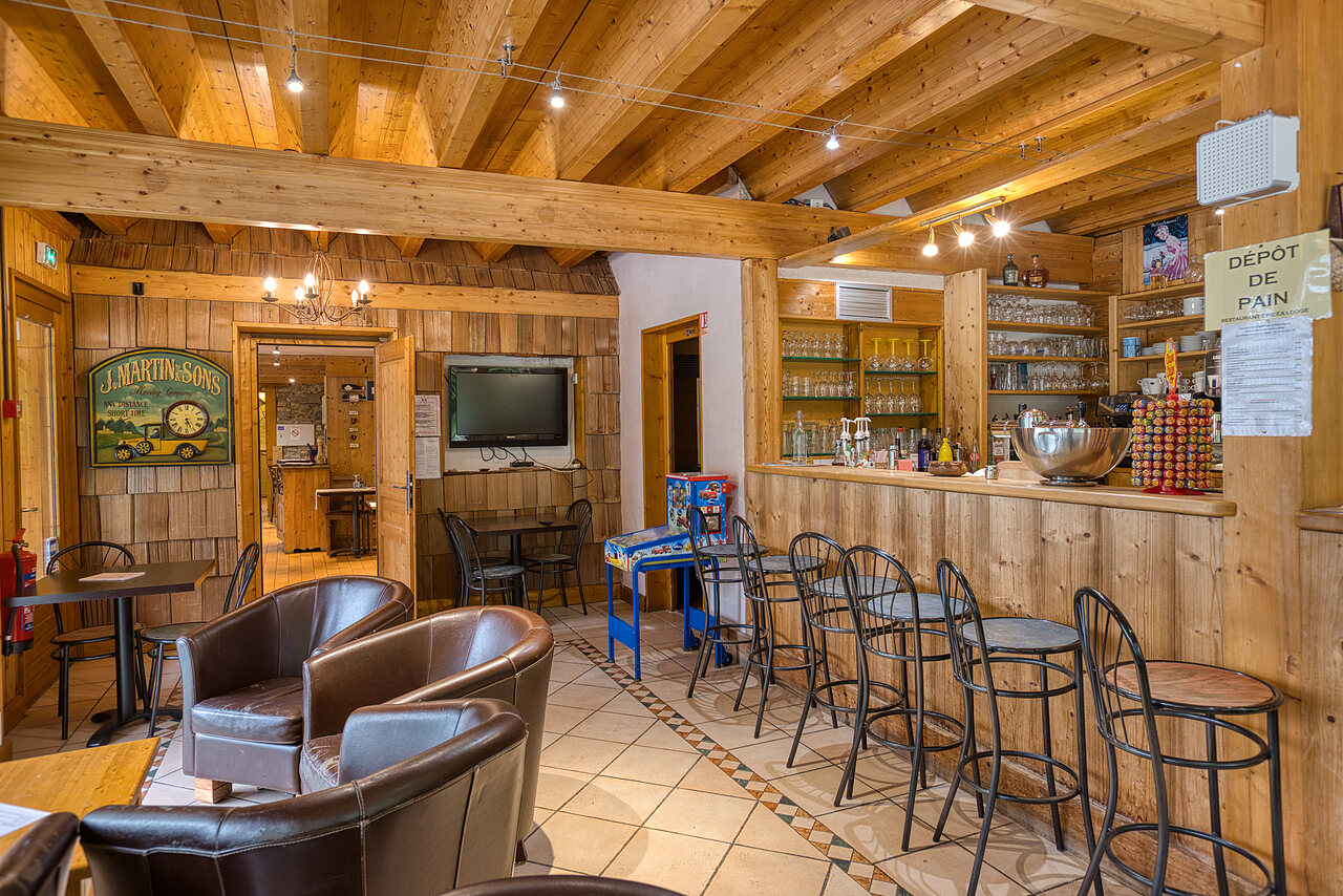 Houten bar, lounge en kruidenierswinkel op camping CLICOCHIC Alpes Lodges in Pralognan la Vanoise (73).