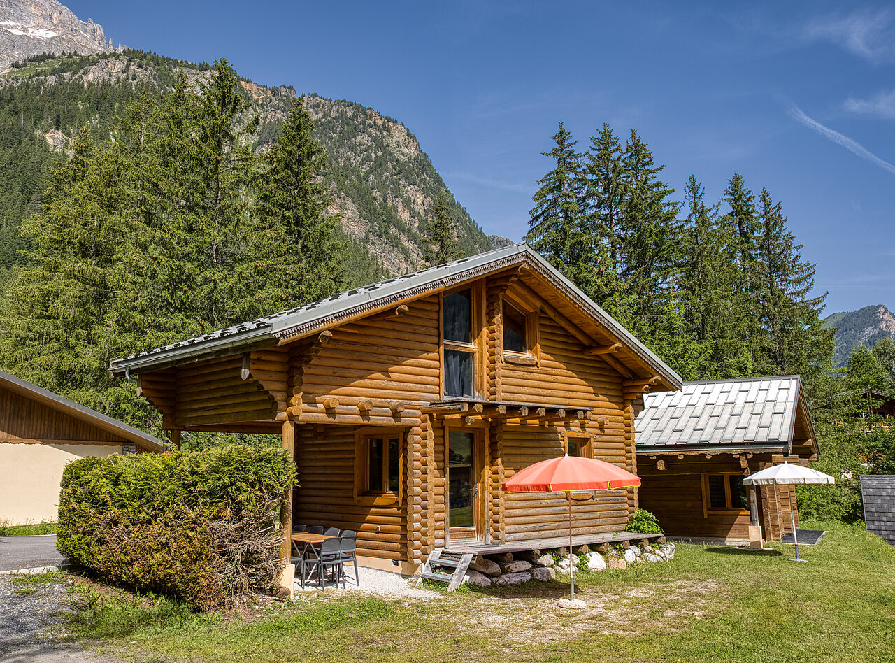 Houten chalet met terras en parasol, bergen op camping CLICOCHIC Alpes Lodges in Pralognan la Vanoise (73).