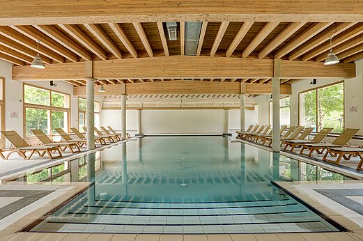 Verwarmd binnenzwembad met ligstoelen op camping CLICOCHIC Alpes Lodges in Pralognan la Vanoise (73).