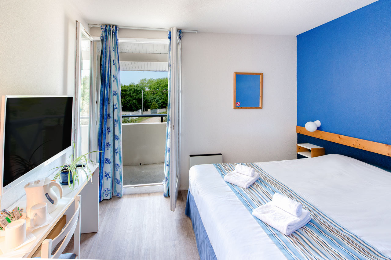 Kamer met tweepersoonsbed, balkon op camping CAPFUN Oc�ane in Andernos.