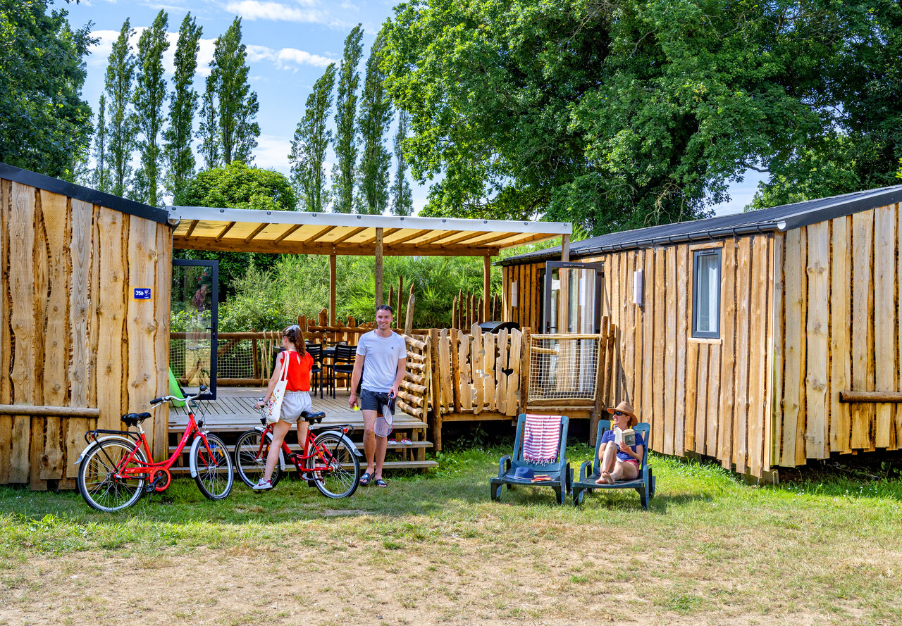 Houten stacaravans, fietsen en familie op camping CAPFUN An Trest in SARZEAU (56).