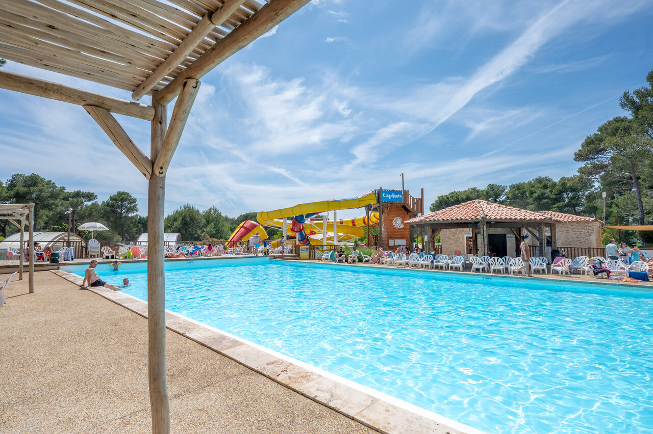 Buitenzwembad, waterglijbanen en ligstoelen op camping CAPFUN Arbois du Castellet (83).