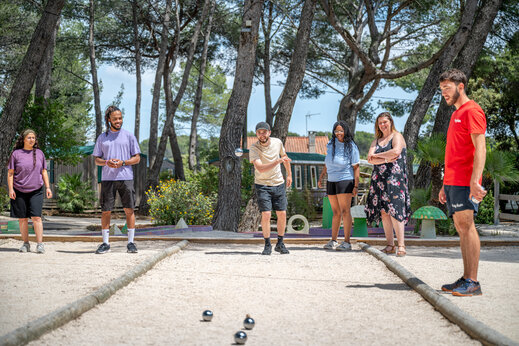 Vrienden spelen jeu de boules op een baan op camping CAPFUN Arbois du Castellet in LE CASTELLET (83).