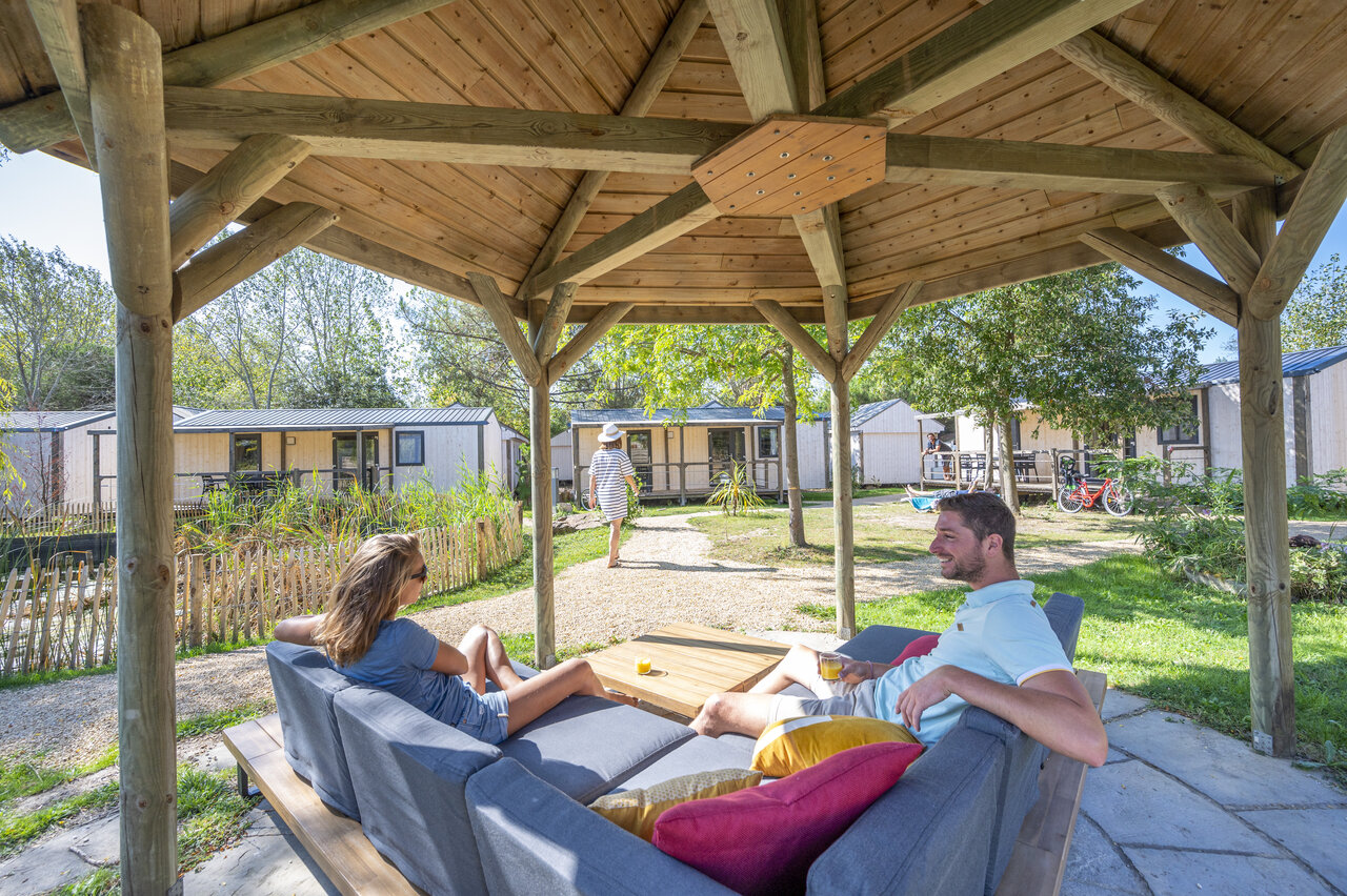 Koppel ontspant onder prieel, stacaravans bij CAPFUN Armor H�ol in Piriac sur Mer.