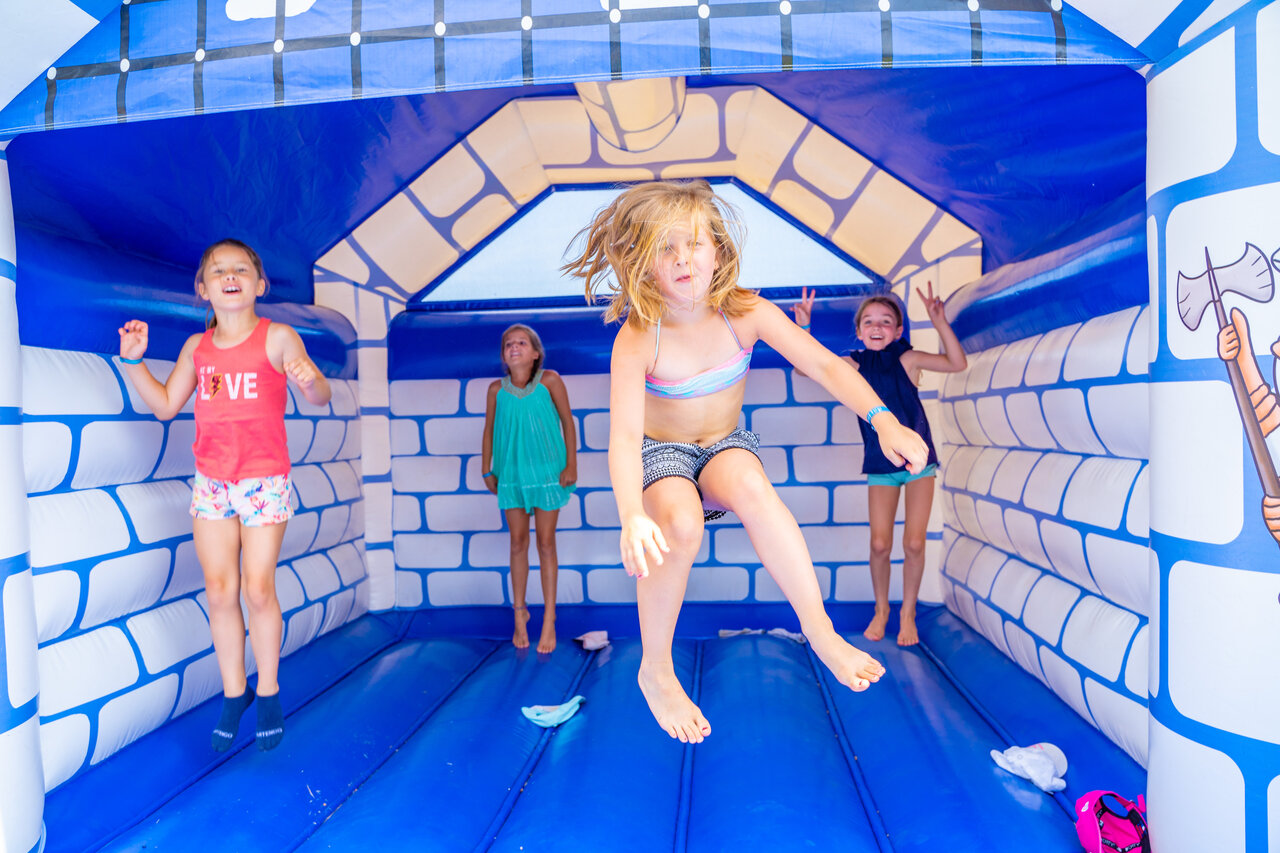 Kinderen springen in blauw-wit springkasteel op camping CAPFUN Armor H�ol in Piriac sur Mer (44).