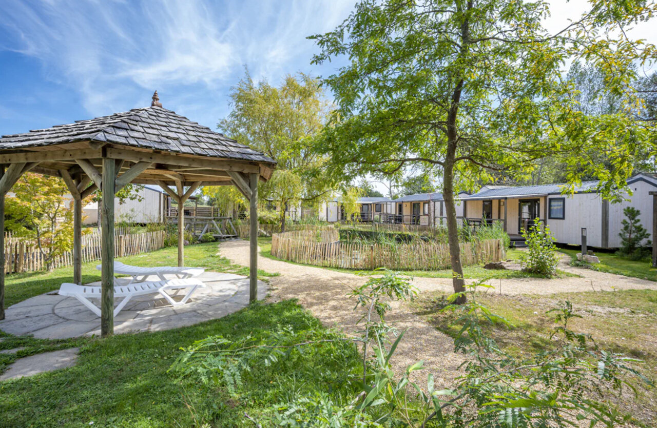 Houten prieel, ligstoelen en stacaravans op camping CAPFUN Armor H�ol in Piriac sur Mer (44).