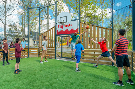 Multisportterrein met jongeren die basketballen op camping CAPFUN Armor Héol.