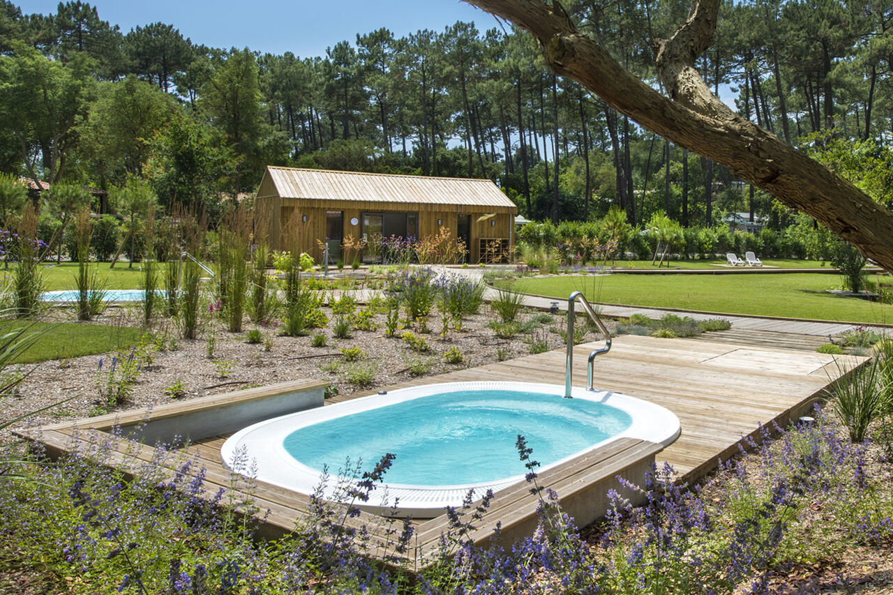 Buitenjacuzzi en ontspanningsruimte op camping LIBRANOO Naturiste Arnaoutchot in Veille-Saint-Girons, Landes, Frankrijk.
