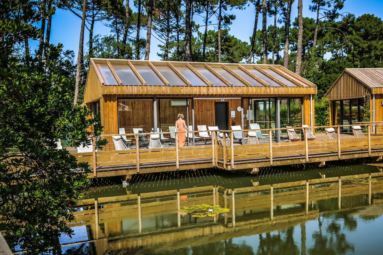 Modern spa gebouw op palen op camping LIBRANOO Naturiste Arnaoutchot in Veille-Saint-Girons, Landes, Frankrijk.