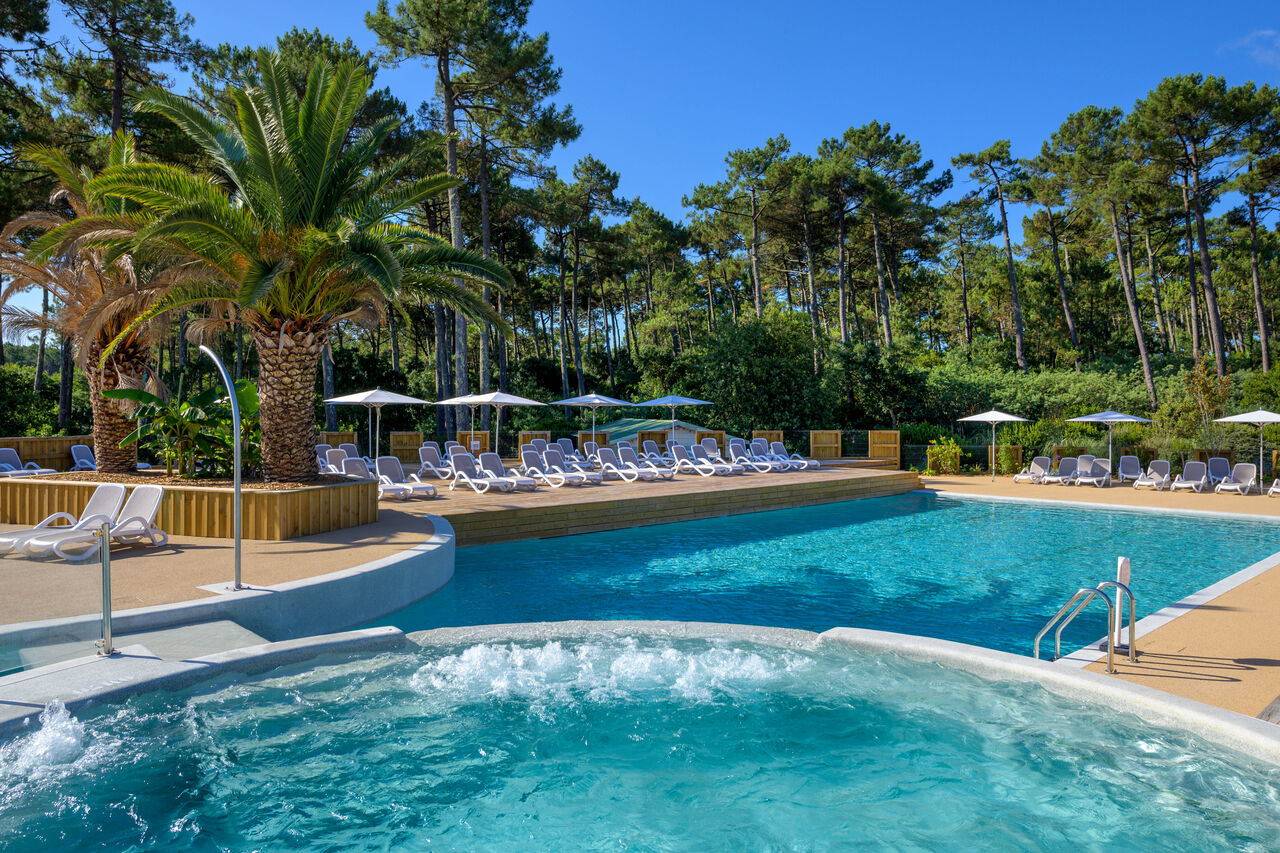 Buitenzwembad, jacuzzi, ligstoelen op camping LIBRANOO Naturiste Arnaoutchot in Veille-Saint-Girons, Landes, Frankrijk.