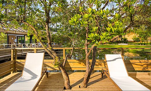 Spa ontspanningsruimte, houten terras en bomen op camping LIBRANOO Naturiste Arnaoutchot in Veille-Saint-Girons, Landes, Frankrijk.