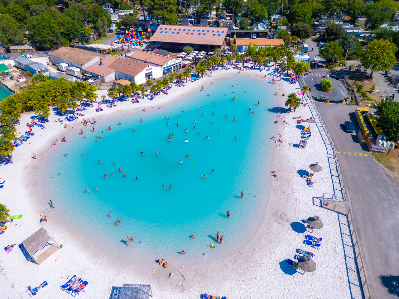 Lagoonzwembad, zandstrand, zwemmers op camping CAPFUN Atlantique Parc.