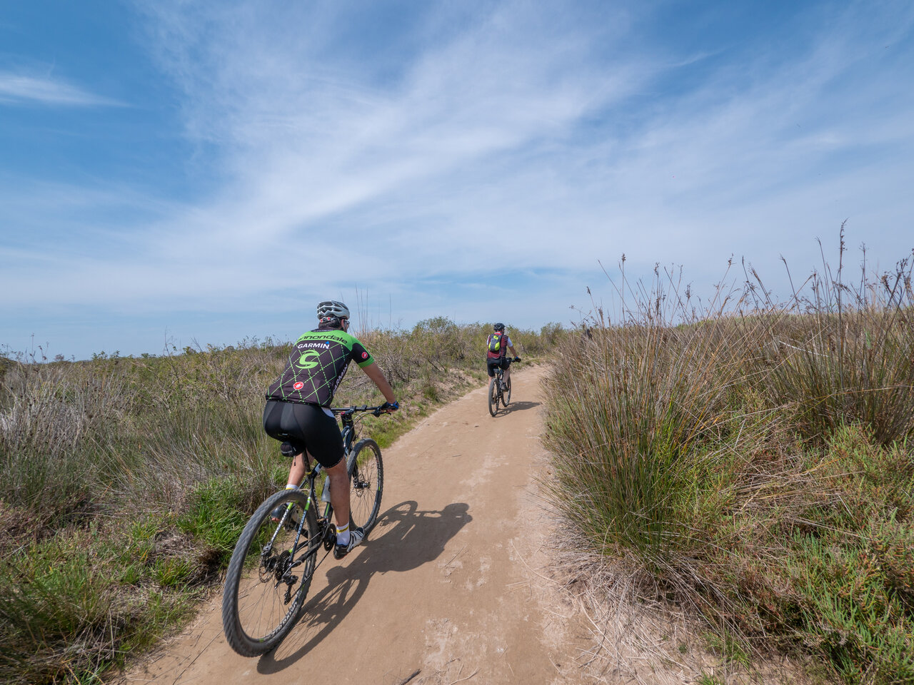 Twee mountainbikers op natuurpad bij camping CAPFUN Aube, Deltebre, Tarragona.