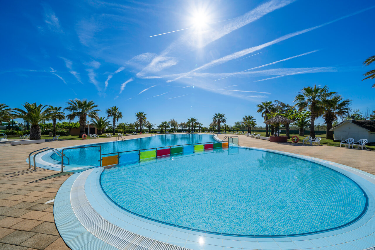 Groot buitenzwembad, gescheiden zones, palmbomen, camping CAPFUN Aube in Deltebre, Tarragona.