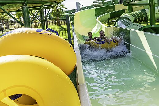 Kinderen op band glijden van waterglijbaan op camping CAPFUN Aube in Deltebre, Tarragona.