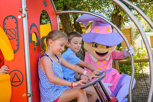 Kinderen en mascotte op de speeltuin van camping CAPFUN Aube in Deltebre, Tarragona.