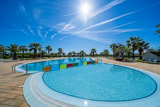 Buitenzwembad met twee baden en palmbomen op camping CAPFUN Aube in Deltebre, Tarragona.