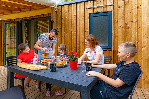 Familie luncht op terras Mobil-home op camping CAPFUN Aube in Deltebre, Tarragona.