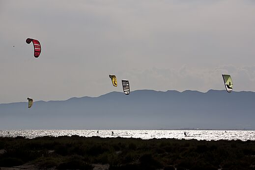 Kitesurfers op het water met bergen op de achtergrond op camping CAPFUN Aube in Deltebre, Tarragona (43).