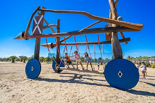 Houten speeltoestel met kinderen op camping CAPFUN Aube in Deltebre, Tarragona.