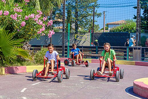 Kinderen op skelters op de baan van camping CAPFUN Aubrèdes (83).