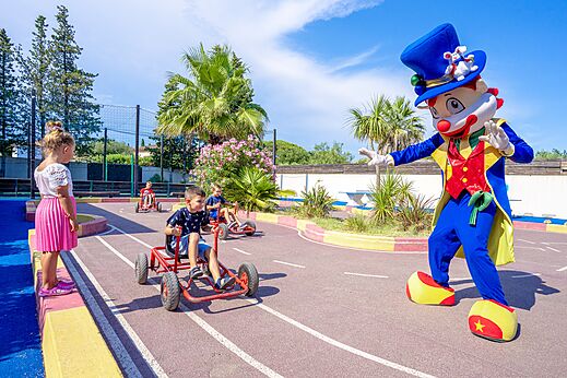 Kinderen op skelters met mascotte op camping CAPFUN Aubr�des (83).