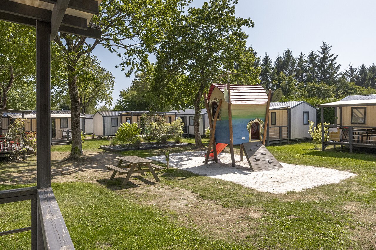 Kinderspeeltuin, speelhuisje, glijbaan en stacaravans op camping CLICOCHIC in Poullan-sur-Mer.