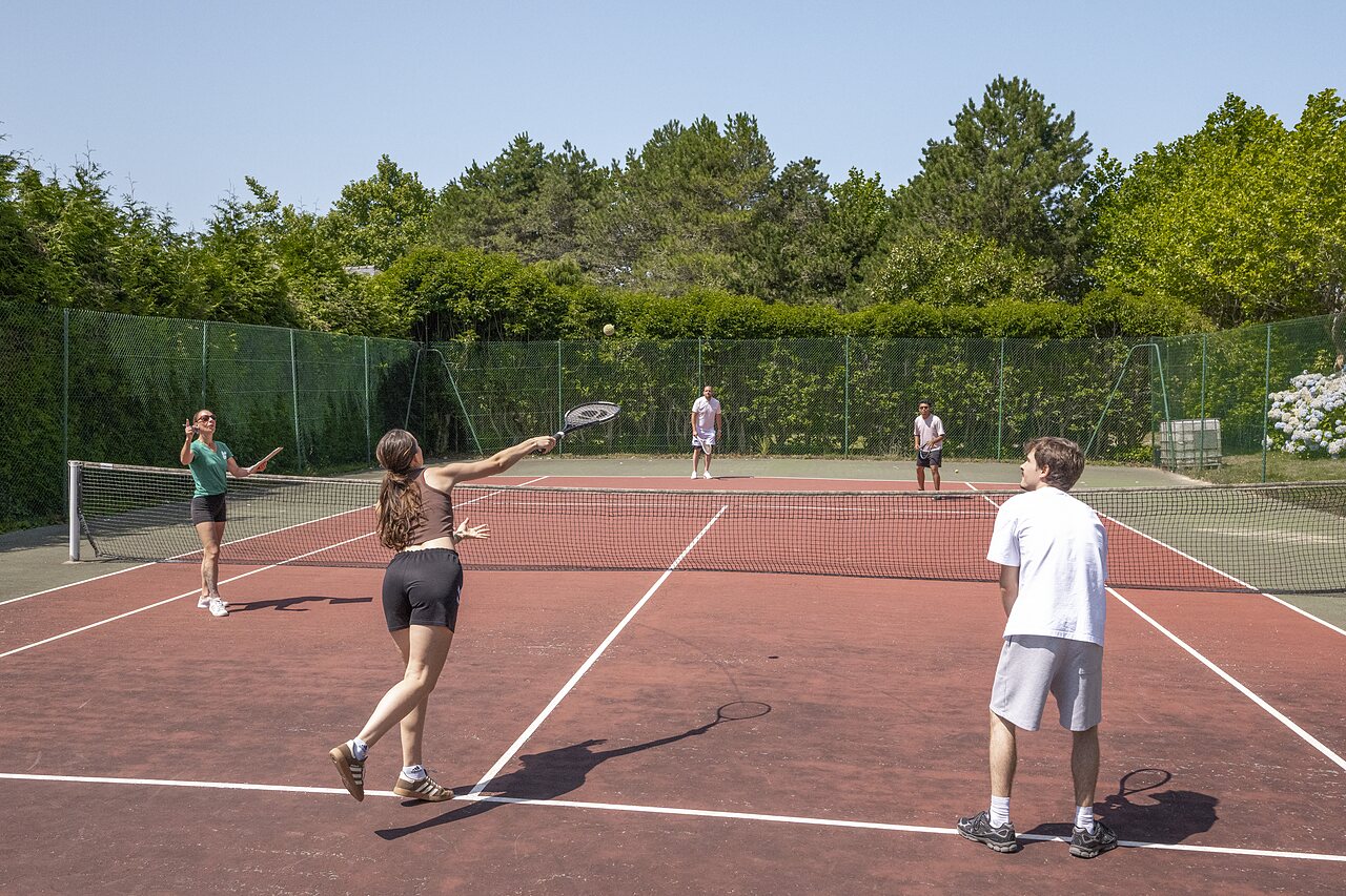 Tennisspelers op de buitenbaan van camping CLICOCHIC Baie de Douarnenez.
