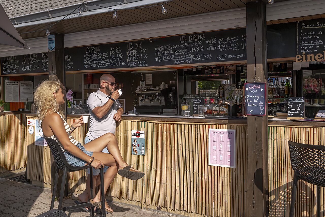 Bar-restaurant met terras, gasten genieten van drankjes en maaltijden op camping CLICOCHIC Baie de Douarnenez.