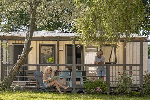 Moderne stacaravan met terras, stel ontspant op camping CLICOCHIC Baie de Douarnenez.
