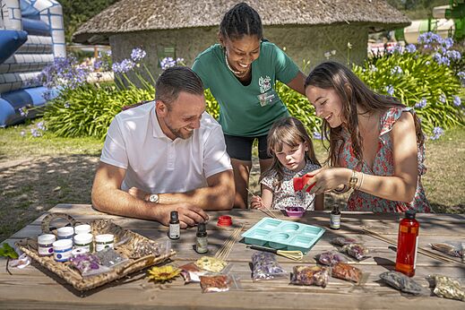 Familie en animator doen mee aan creatieve workshop op camping CLICOCHIC Baie de Douarnenez in Poullan-sur-Mer (29).