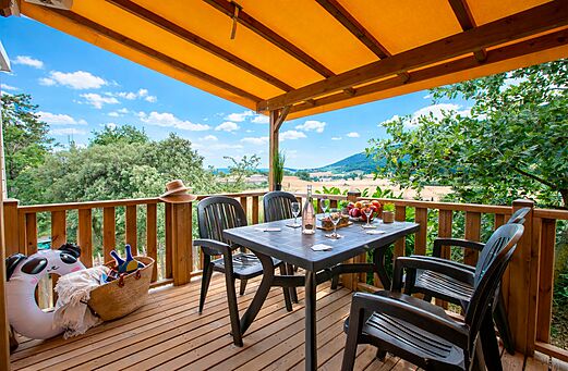 Terras van stacaravan met tafel, stoelen op camping CLICOCHIC Bastets Marsanne.