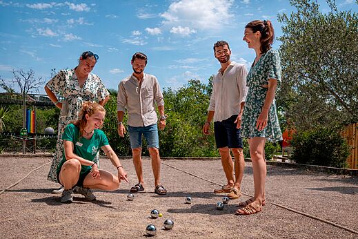 Vrienden spelen jeu de boules op het terrein van camping CLICOCHIC Bastets.
