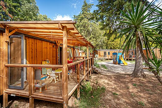 Houten stacaravan met overdekt terras en speeltuin op camping CAPFUN Bastide in Nîmes (30).
