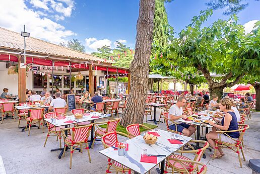 Buitenrestaurantterras met gasten op camping CAPFUN Bastide in Nîmes (30).