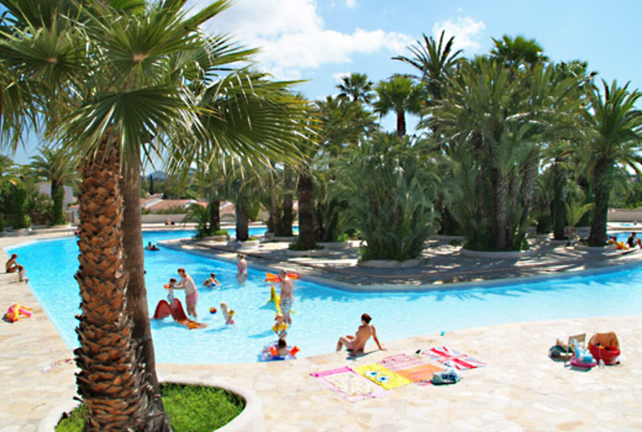Groot buitenzwembad met palmbomen en waterspelen op camping CAPFUN La Baume - La Palmeraie in Fr�jus (83).