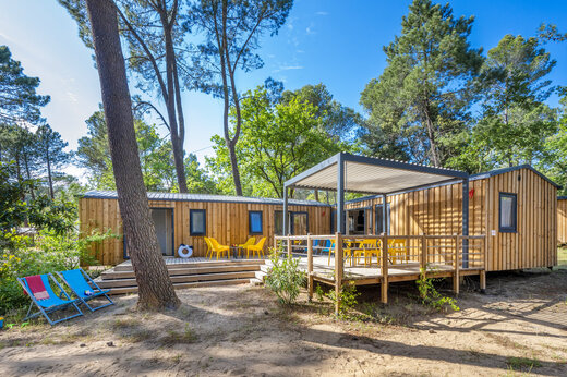 Houten stacaravan met terras en stoelen op camping CAPFUN Beauregard in MORNAS (84).