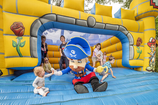 Opblaasbaar piratenschip en spelende kinderen op camping CAPFUN Beauregard in MORNAS (84).