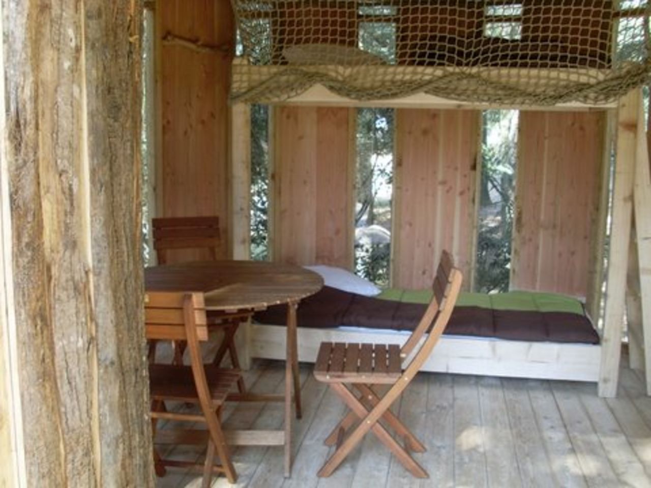 Houten boomhut, bed, tafel op camping CAPFUN Beauregard in Mornas.
