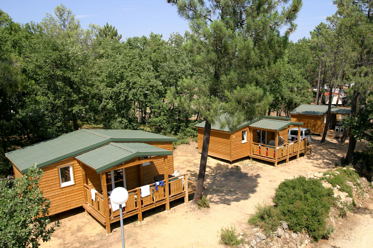 Houten chalets met schaduwrijke terrassen op camping CAPFUN Beauregard in Mornas (84).