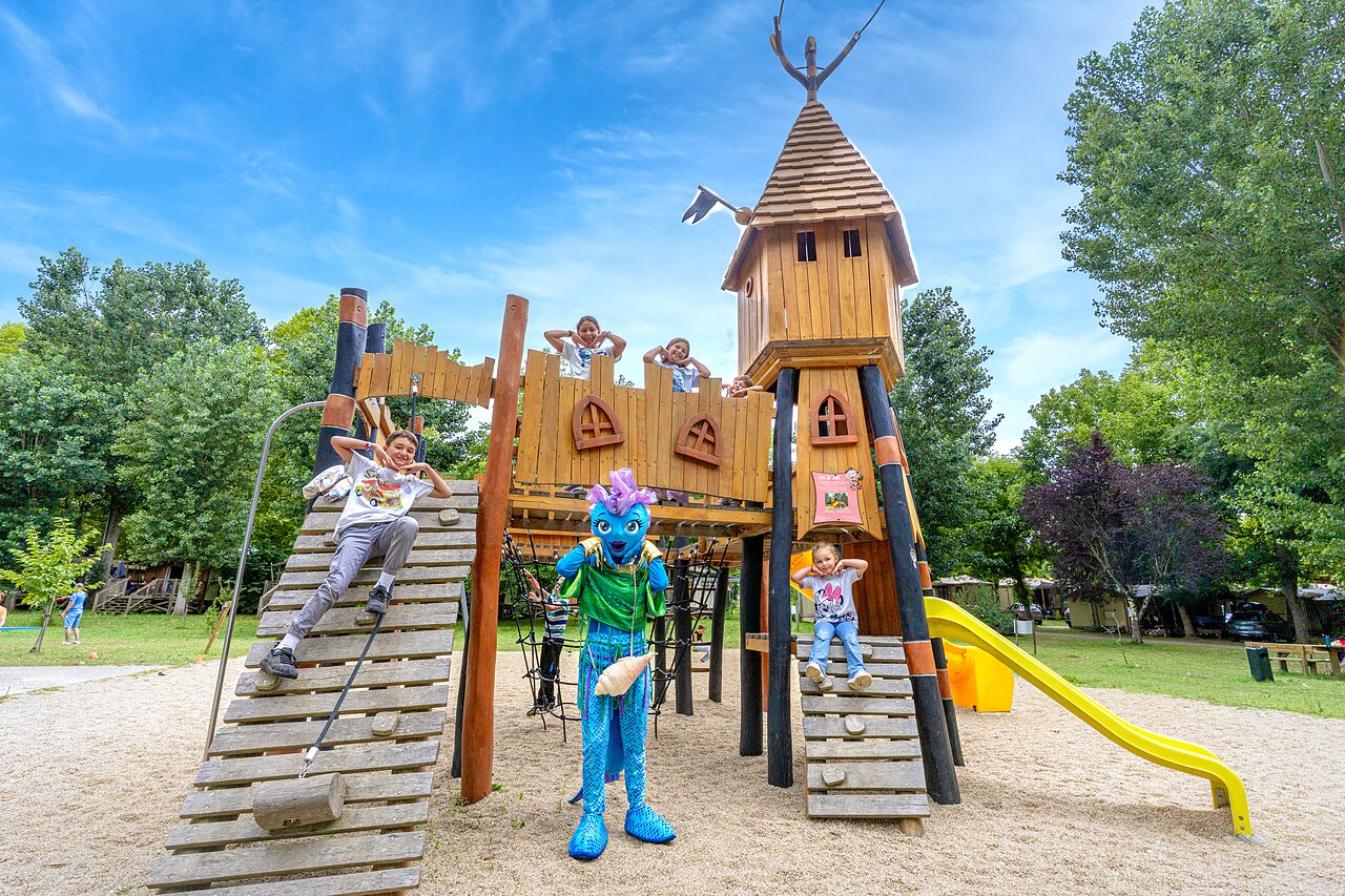 Houten speeltuin, kinderen en mascotte op camping CLICOCHIC Beau Rivage in LA ROQUE-GAGEAC (24).