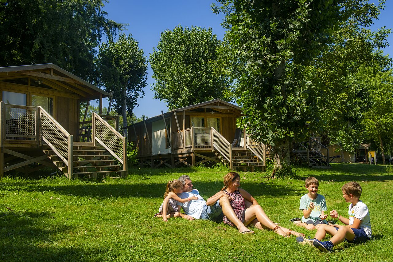 Houten chalets, familie op camping CLICOCHIC Beau Rivage in LA ROQUE-GAGEAC (24).
