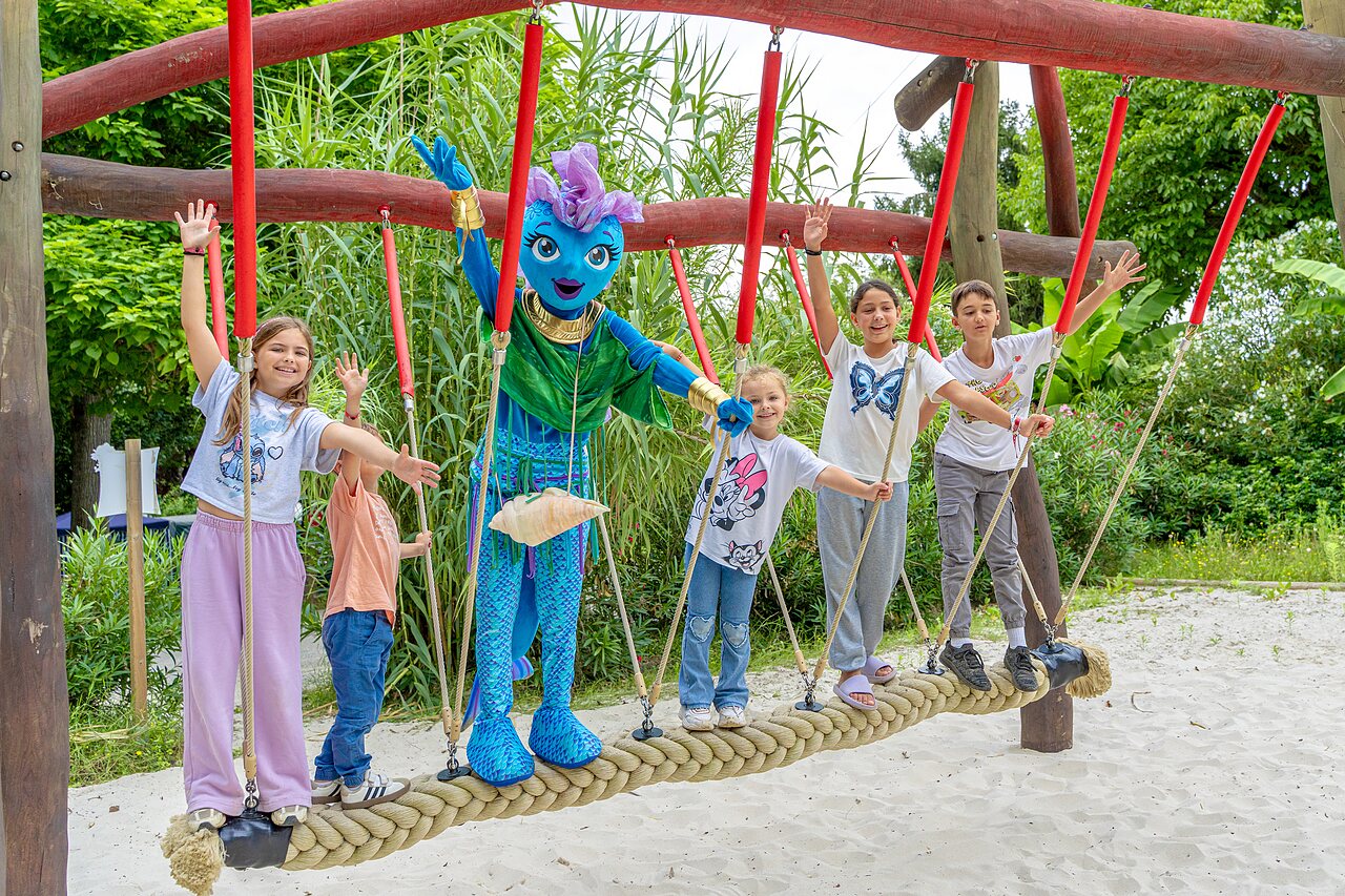 Kinderen en mascotte op touwbrug, speeltuin op camping CLICOCHIC Beau Rivage in LA ROQUE-GAGEAC (24).