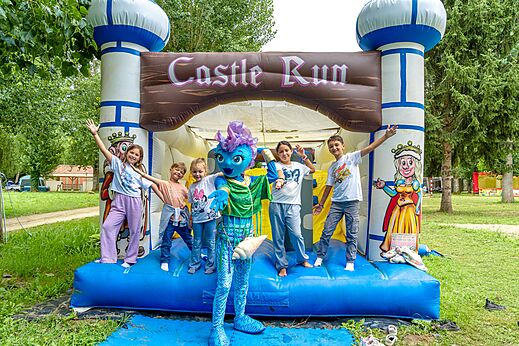 Opblaasbaar kasteel Castle Run, kinderen en mascotte op camping CLICOCHIC Beau Rivage.