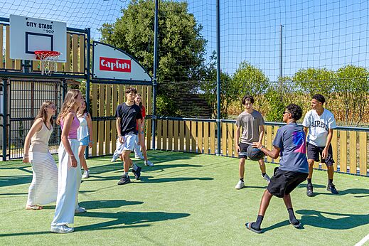 Jongeren basketballen op het multisportterrein City Stade op camping CAPFUN Bel Air in Aiguillon sur Mer (85).