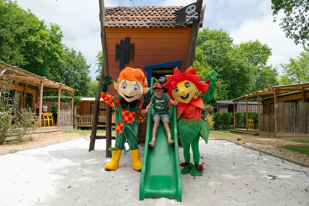 Kind op glijbaan, mascottes en speeltuin op camping CLICOCHIC Bimbo in BISCARROSSE (40).